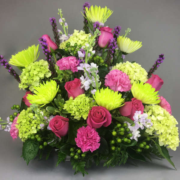 Bright pink roses and lime-green blooms in a mixed bouquet