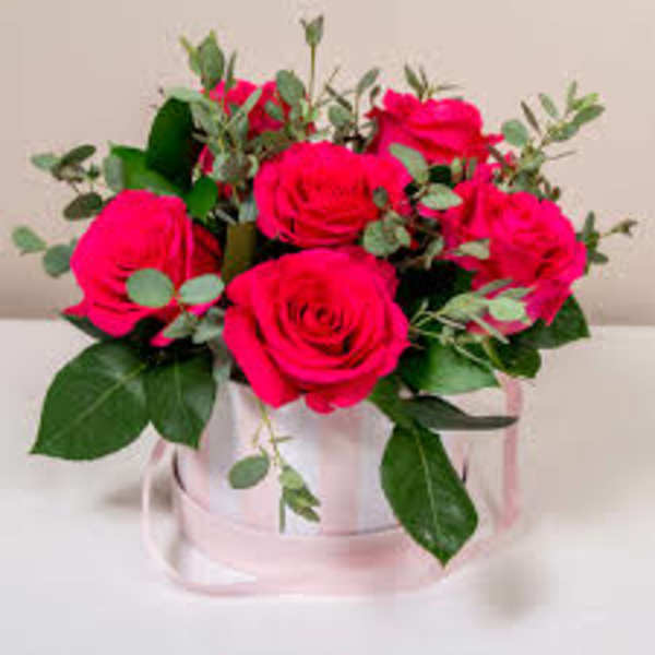 Pink rose bouquet in a clear box with a pink ribbon