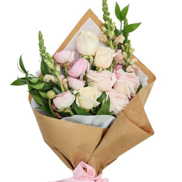 Bouquet of pale pink and cream roses wrapped in brown paper