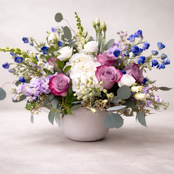Mixed bouquet of pink and white flowers in a white vase
