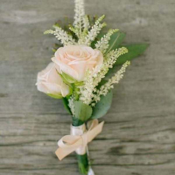 Small boutonniere with pale pink roses and white filler flowers