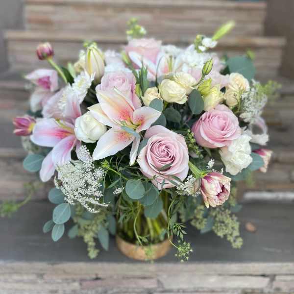 Pink roses and lilies arranged in a vase with soft greenery