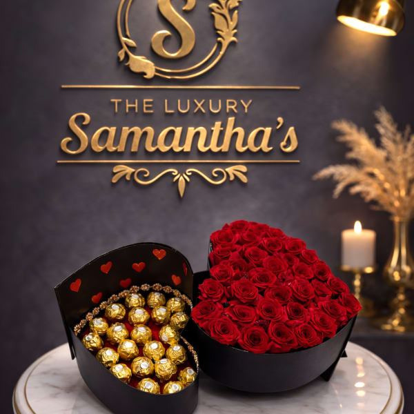 Heart-shaped box of red roses beside a box of gold-wrapped chocolates