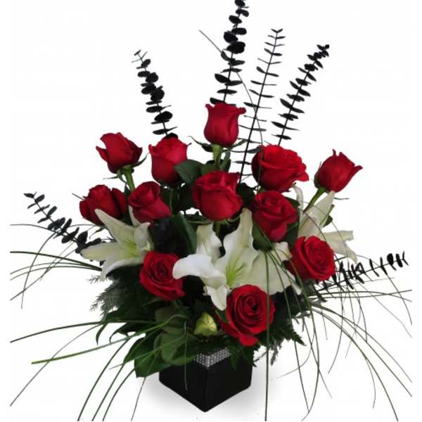 Red roses and white lilies in a black vase with tall black stems