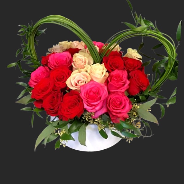 Heart-shaped rose arrangement in a white container