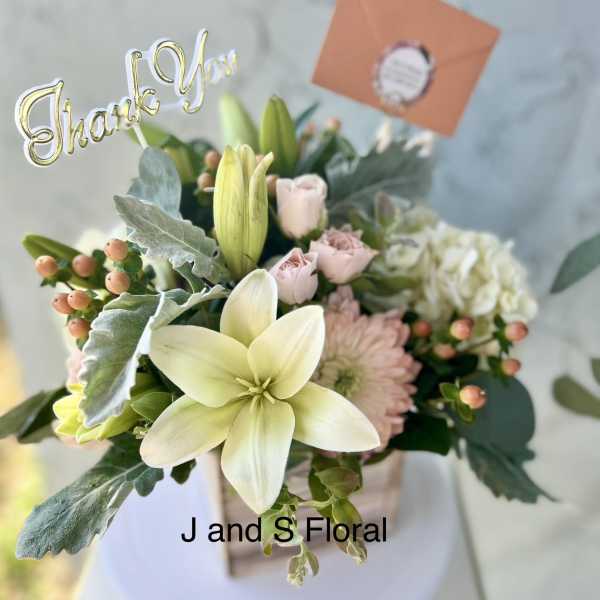 Bouquet of pale lilies and blush roses with a thank-you topper