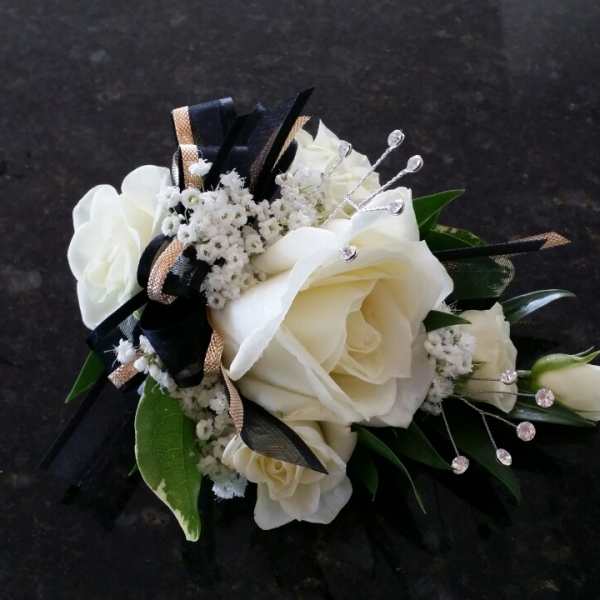 White rose corsage with black and gold ribbon accents
