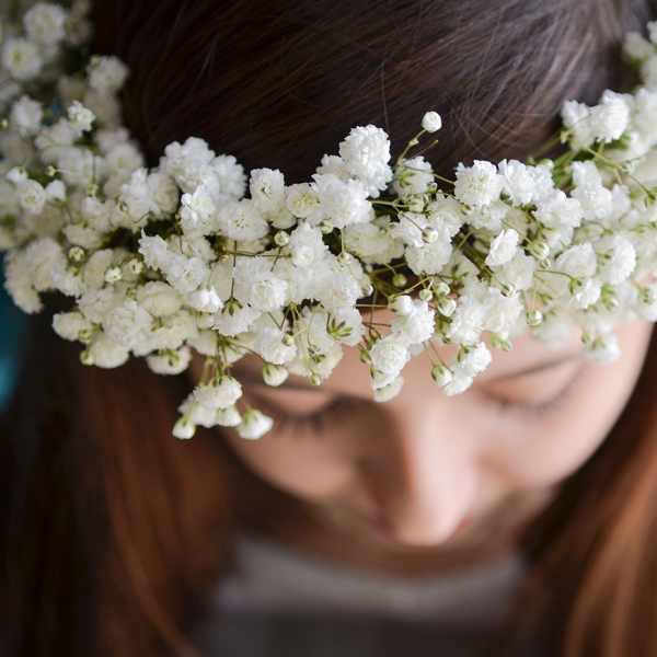 White baby’s breath flower crown worn on a girl’s head, viewed from above