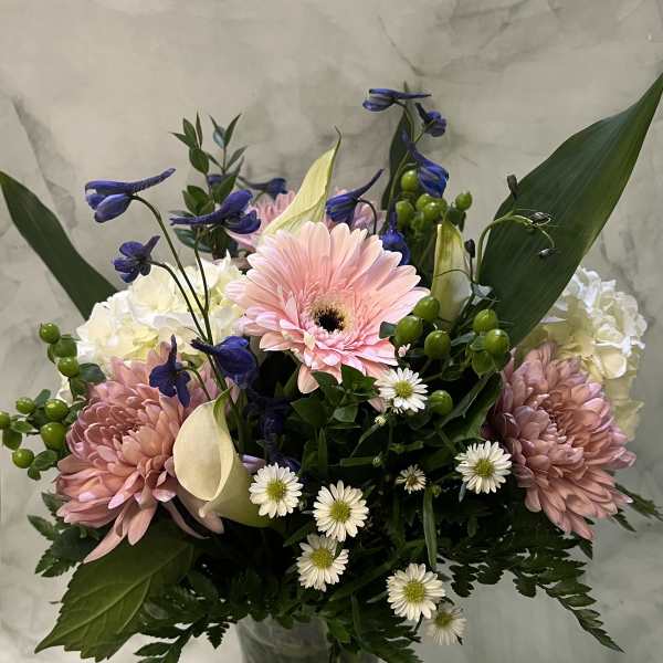 Mixed bouquet in a clear glass vase with pink gerberas and white calla lilies