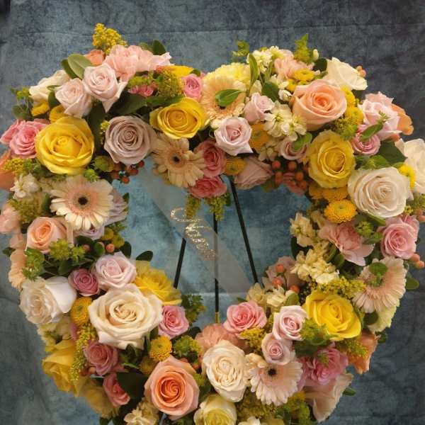 Heart-shaped floral wreath with roses, gerbera daisies, and yellow blooms