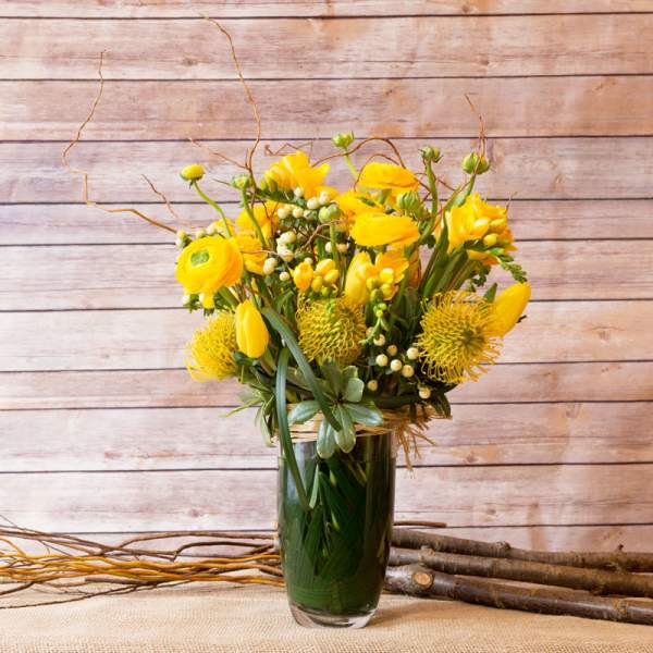 Yellow floral arrangement in a clear glass vase