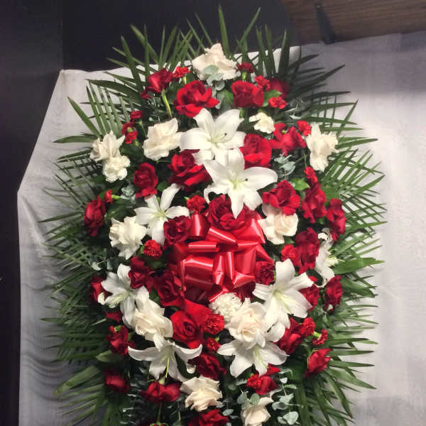 Red and white floral standing spray with a red bow