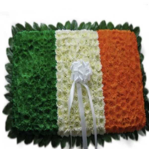 Floral tribute in green, white, and orange with a white ribbon bow