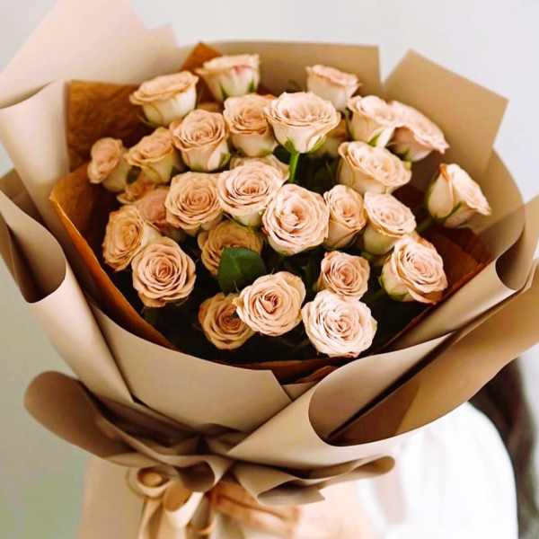 Bouquet of pale peach roses wrapped in brown paper