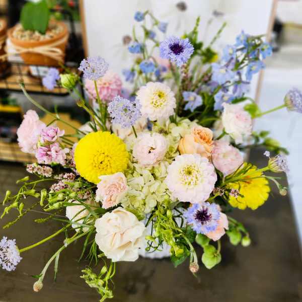 Mixed pastel bouquet with yellow and white blooms in a vase