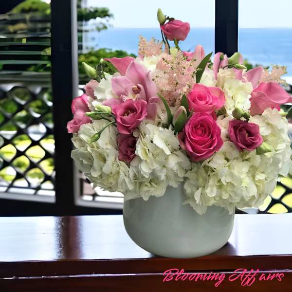 Pink roses and lilies arranged in a white vase