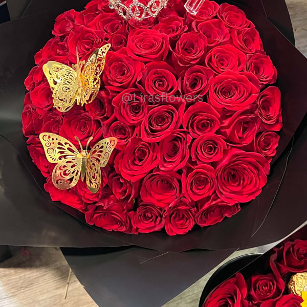 Round bouquet of red roses with a tiara and gold butterfly decorations