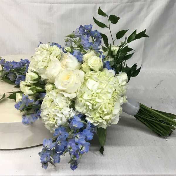 Bouquet of white hydrangeas and blue flowers with greenery