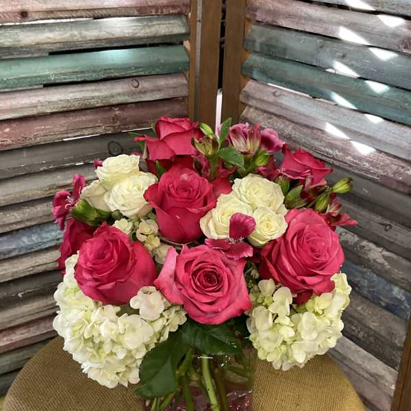 Pink and white roses with hydrangeas in a glass vase