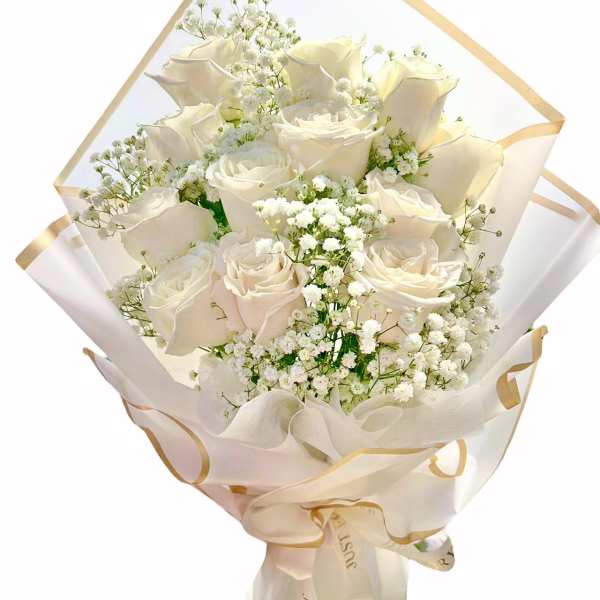 Bouquet of white roses and baby's breath wrapped in cream paper