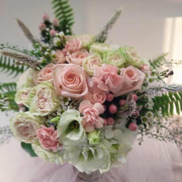 Pastel bouquet of roses, carnations, and lisianthus with airy greenery