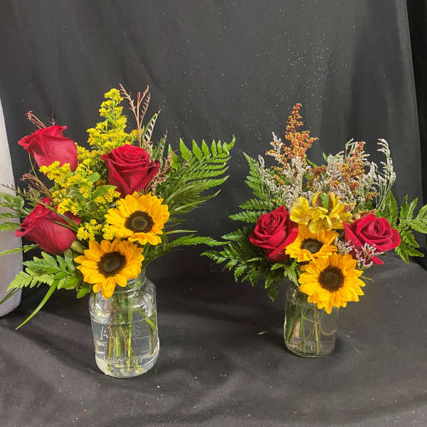 Two small vase arrangements with red roses and sunflowers