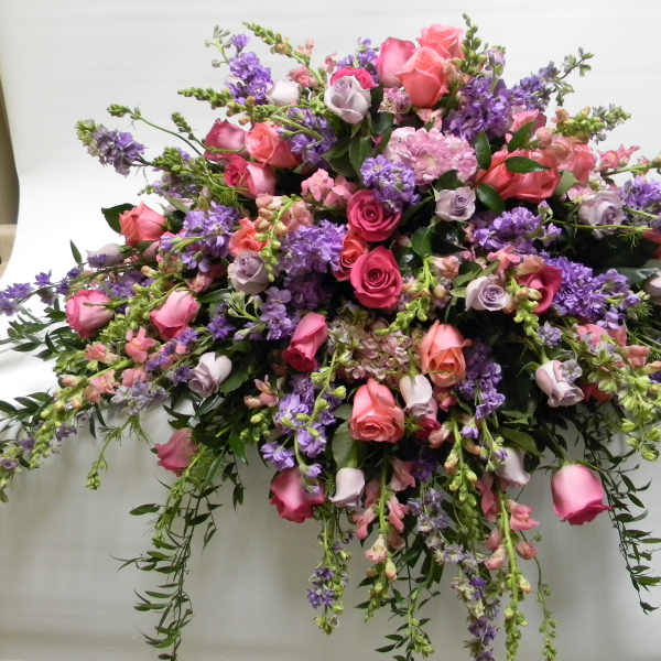 Large bouquet of pink and purple roses with trailing flowers
