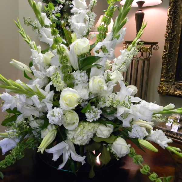 Large white floral arrangement with roses and lilies in a vase