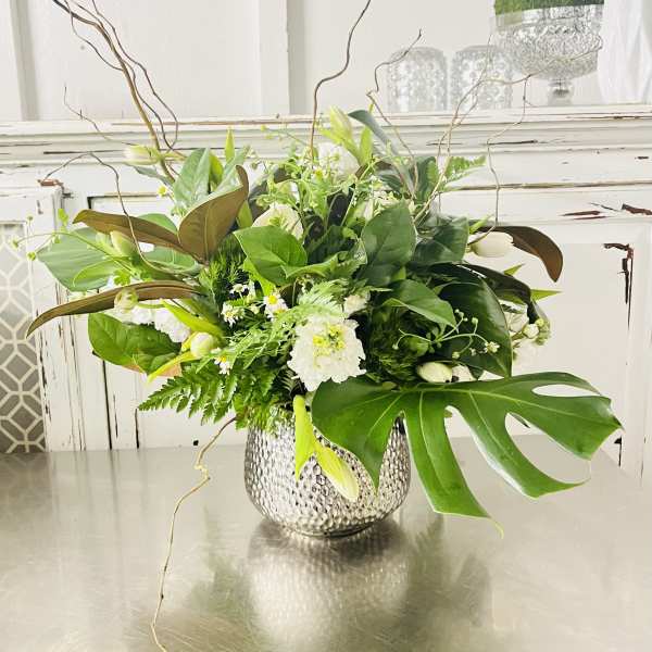 White and green floral arrangement in a hammered silver vase