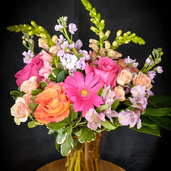 Mixed pink and peach flowers in a glass vase