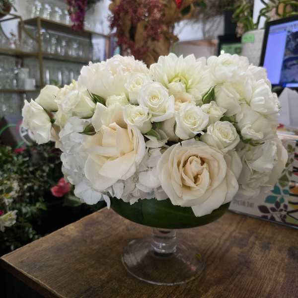 White and cream roses arranged in a clear glass vase