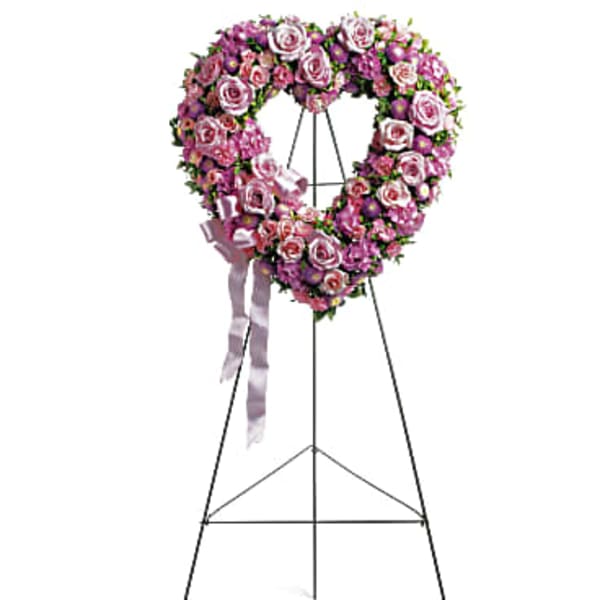 Heart-shaped pink rose wreath on a standing easel with ribbon