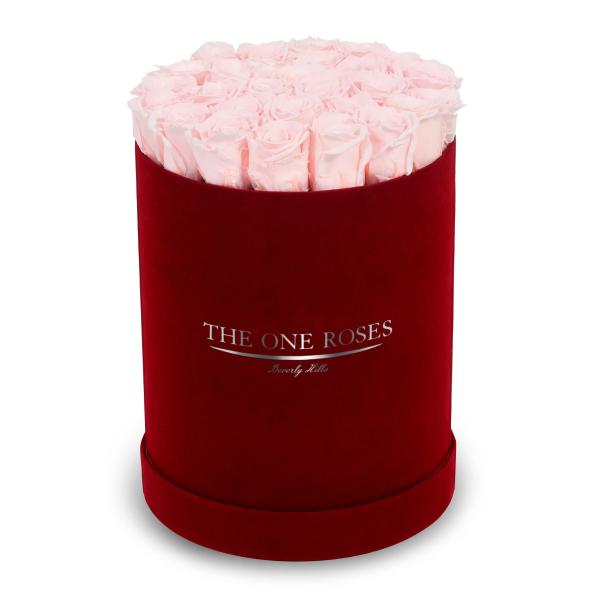 Pink roses arranged in a red velvet hat box