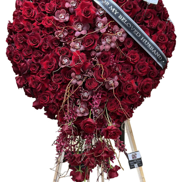 Heart-shaped red rose standing spray with a memorial ribbon
