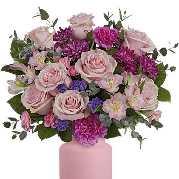Pink roses and purple flowers arranged in a pink vase