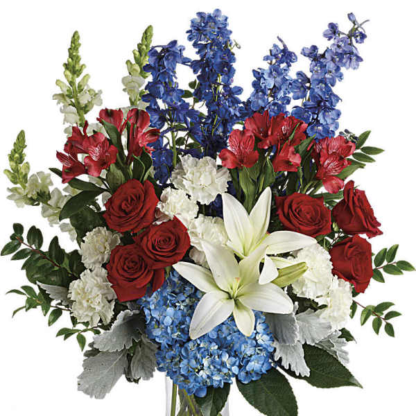 Red roses, white lilies, and blue flowers in a glass vase