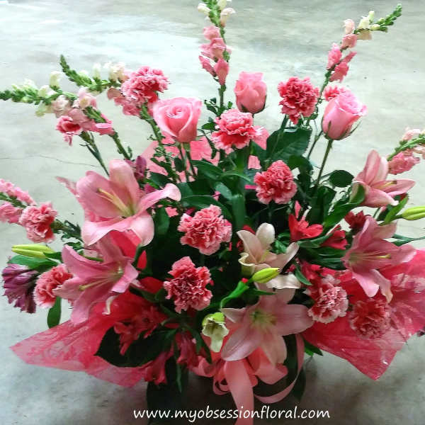 Pink lilies, roses, and carnations in a decorative bouquet