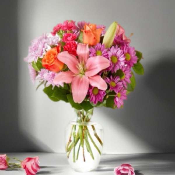 Pink and orange mixed bouquet in a clear glass vase