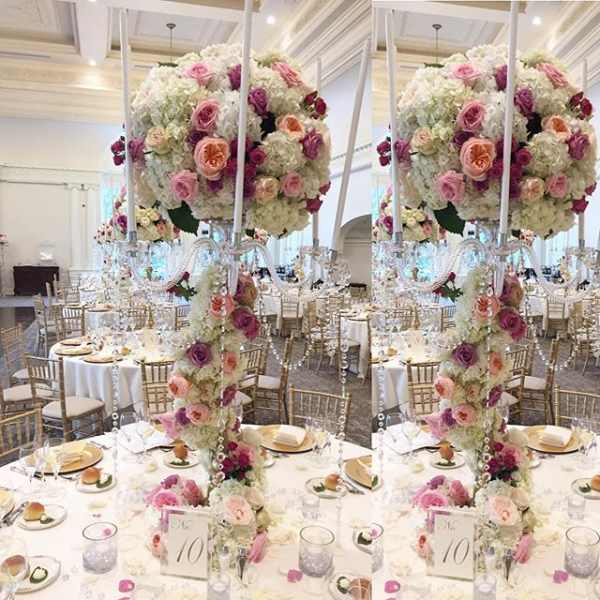 Tall floral centerpiece with pink and white roses at a banquet table