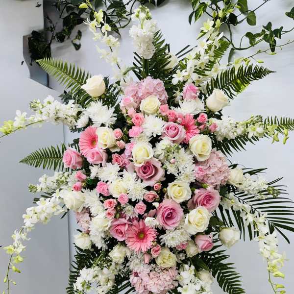 Large standing floral spray with pink and white flowers on an easel