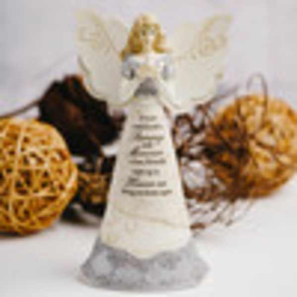 Angel figurine with white wings and a long dress, surrounded by decorative spheres