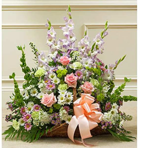 Basket arrangement of pink roses, daisies, and tall lavender flowers with a peach ribbon