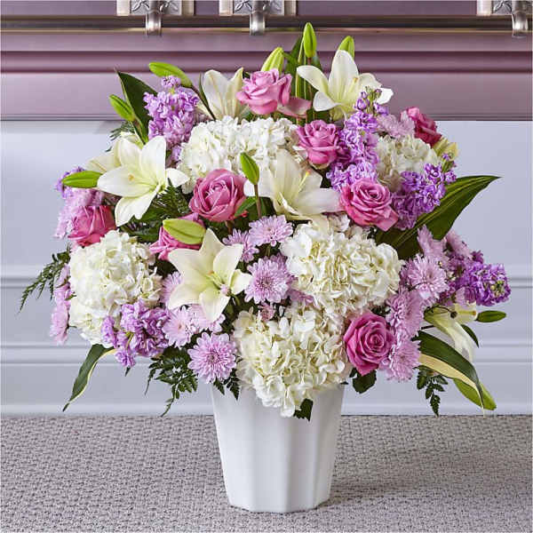Pink roses and white lilies in a white vase