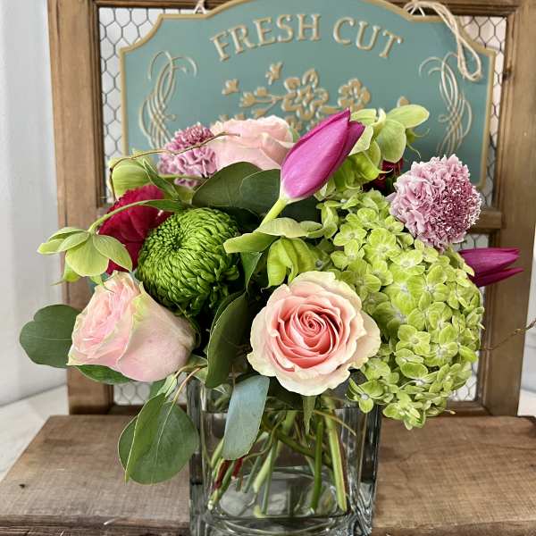 Pink roses and green hydrangeas in a clear square vase