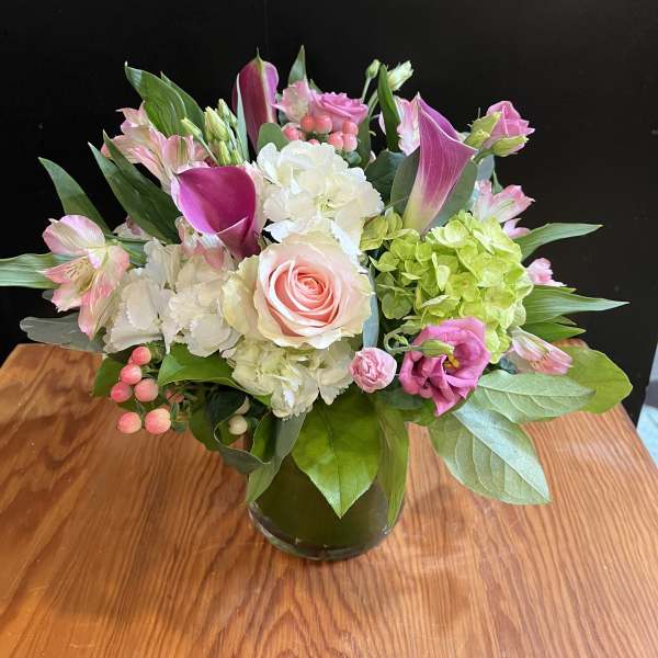 Pink and white mixed flower arrangement in a glass vase