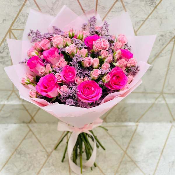 Bouquet of pink roses wrapped in pale pink paper