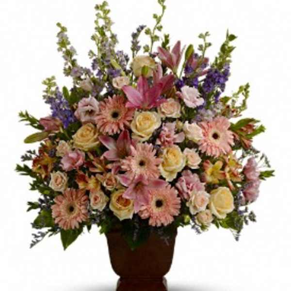 Large mixed bouquet in a brown urn vase with pink and cream flowers