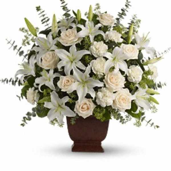 White lilies and cream roses arranged in a brown urn vase