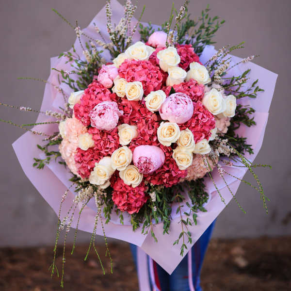 Pink and cream bouquet with roses and hydrangeas wrapped in lavender paper