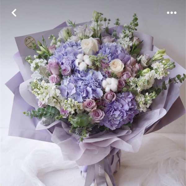 Lavender bouquet with roses and hydrangeas wrapped in lilac paper